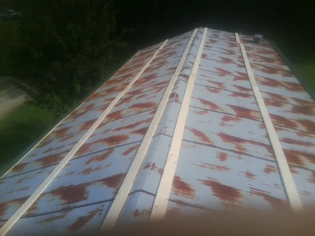 Rusted metal roof panels with new wood purlins before replacement — Storm Damage Roof Repair in Mc Intosh by Roofing Brothers