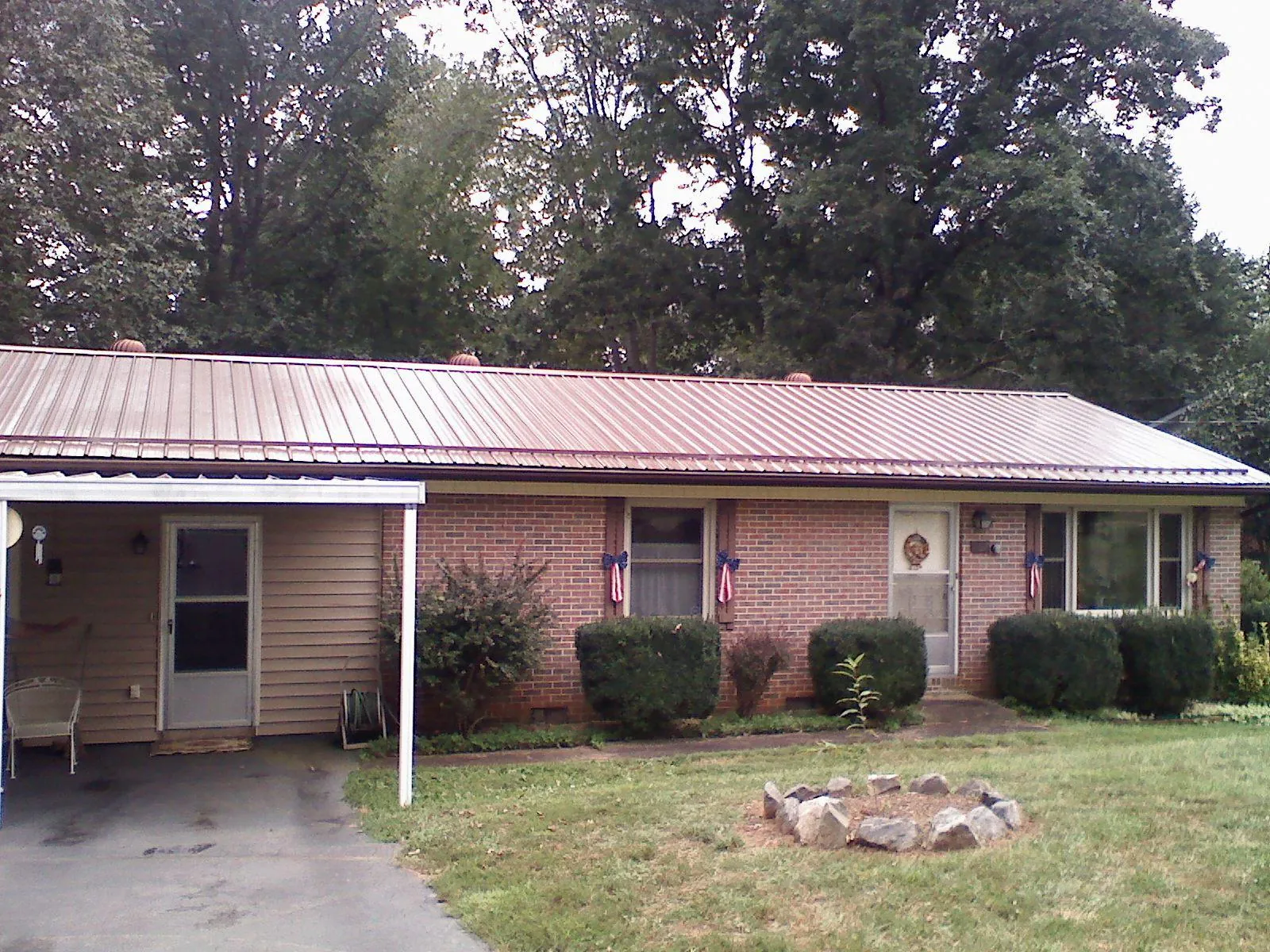 Bronze metal roof and carport on a brick ranch home — Roof Repair work by our crew in Mc Intosh